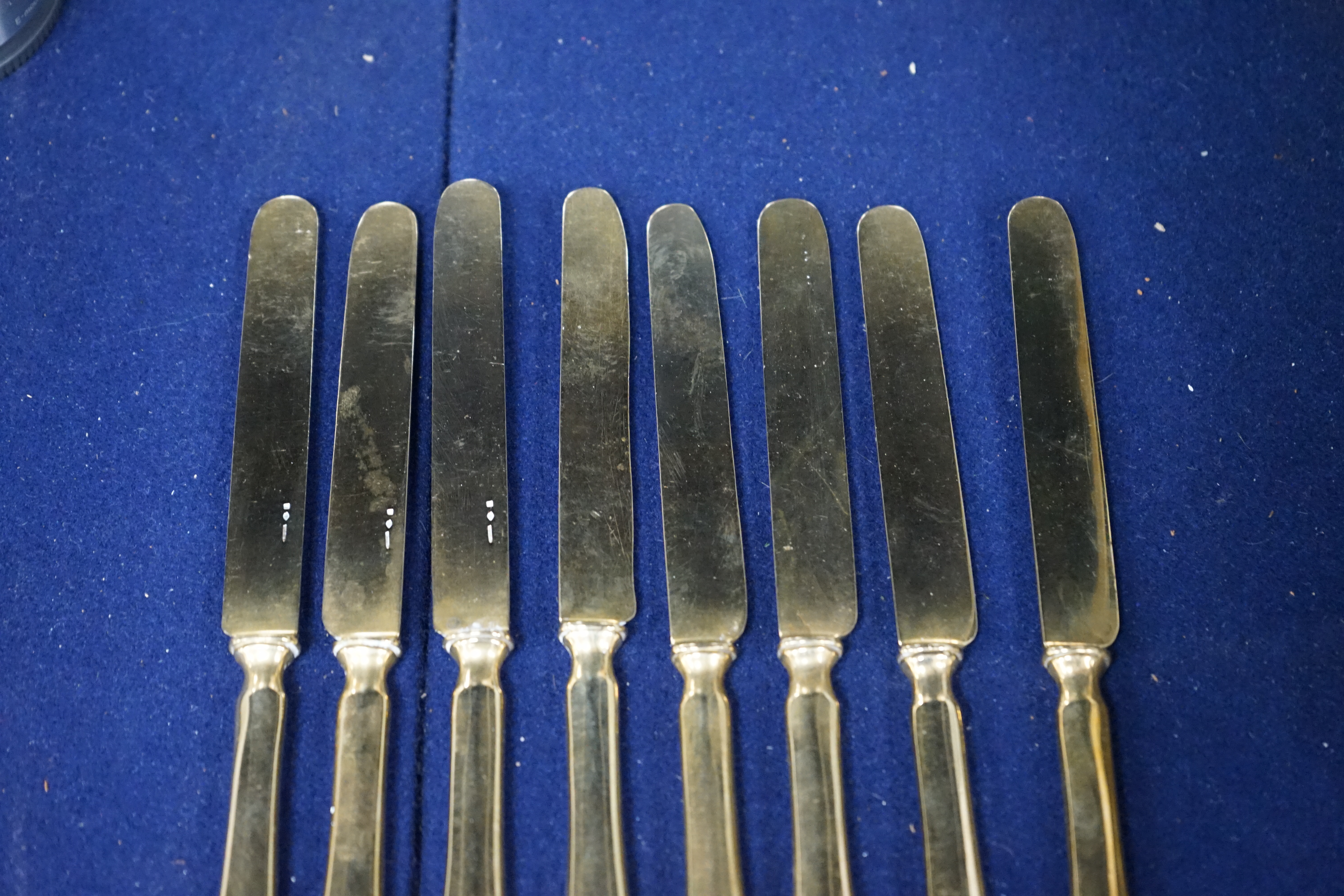 A set of eight French gilt plated dessert knives, 20cm. Condition- fair to good, some nicks and scratches